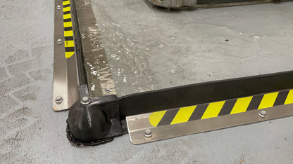 ECCOTARP Floor ET Barrier golvbarriär kemiskt resistenta gummibarriärer 55 mm hög spillförhindrande barriär lagerhallar industrigolv truckgenomfart forklift traversering rostfria ankarskruvar betongankring hörnkopplingar oändlig längd 10 m segment kundanpassad form silikon tätningsmedel SDS-Plus borrning reflexdekaler säkerhetsmärkning mekaniskt hållbar kemikalieresistent gummi rostfritt stål AISI 304 plastkopplingar 90° hörn 120° hörn väggslut enkel reparation snabb installation obegränsad formbarriär farl