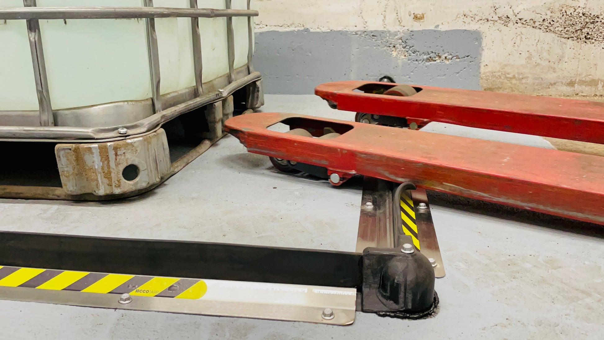 ECCOTARP Floor ET Barrier golvbarriär kemiskt resistenta gummibarriärer 55 mm hög spillförhindrande barriär lagerhallar industrigolv truckgenomfart forklift traversering rostfria ankarskruvar betongankring hörnkopplingar oändlig längd 10 m segment kundanpassad form silikon tätningsmedel SDS-Plus borrning reflexdekaler säkerhetsmärkning mekaniskt hållbar kemikalieresistent gummi rostfritt stål AISI 304 plastkopplingar 90° hörn 120° hörn väggslut enkel reparation snabb installation obegränsad formbarriär farl