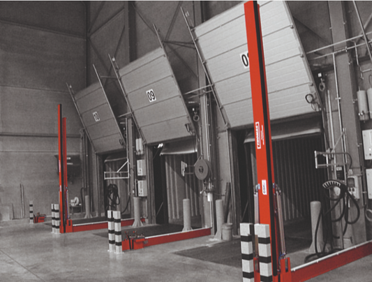 Automatiska släckvattenbarriärer Thomas Sys Tech FM Approved TÜV certifierad släckvattenbarriär brandsäker barriär kemikaliebeständig tätning PTFE PPA pulverlackerad RAL 3000 flammande röd korrosionsskydd elektropneumatisk styrning tryckluftslagring helautomatisk aktivering brandlarm potentialfri brytarkontakt optisk indikering grön röd akustisk varning nöddrift nödtillbrygga sänkta försäkringspremier FM Global VdS certifierad industriell barriär farligt gods lager logistikcenter lastkaj produktionsanläggni