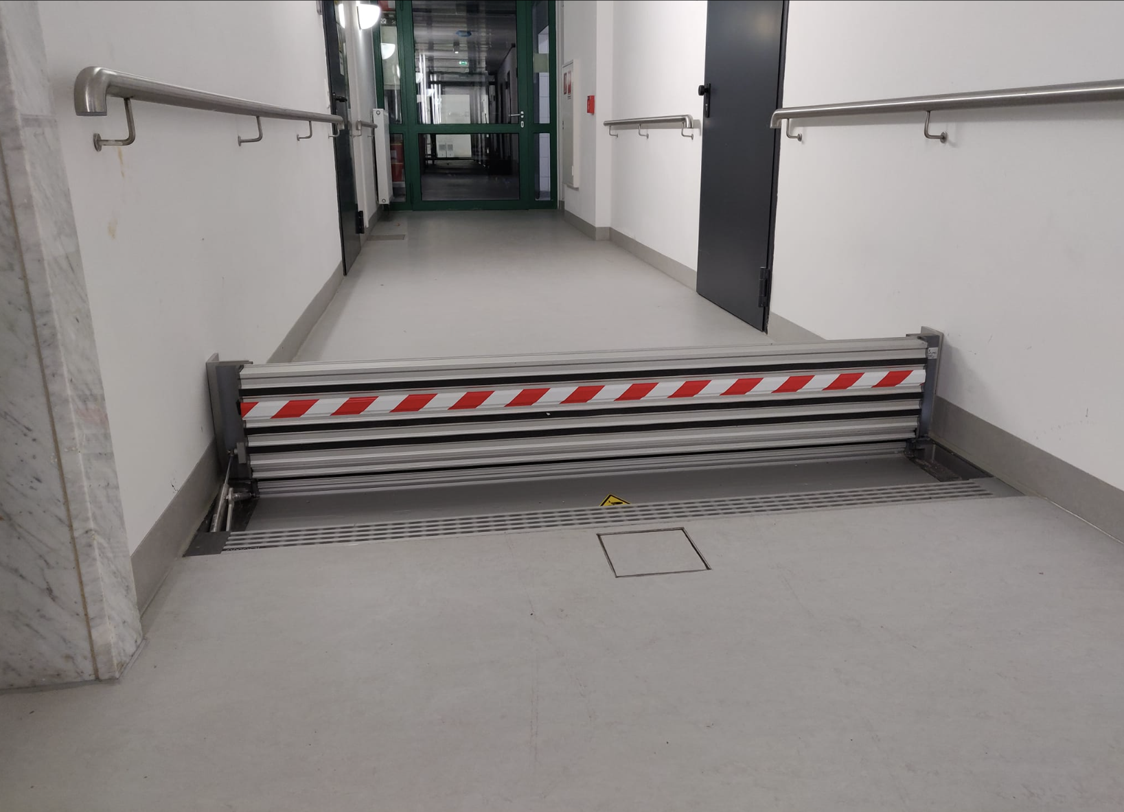 AMARI Hydromatisk Skyddsvall vikbar skyddsvall översvämningsskydd automatisk aktivering utan el hydromatisk översvämningsbarriär skydd mot kraftiga regn vattenintrång innovativ vikbar vall pålitligt översvämningsskydd för industrier kommuner privatpersoner AMARI AE-Wasserbarriere löschvattenbarriär automatisk högvattenbarriär maximal stauhöjd 30 cm einbautiefe 6-70 mm aluminiumprofil patent mekanism gastryckfjädrar EPDM-dichtung rigol kanalisation schwimmbarriär klappschott överfahrbar betong asfalt monteri